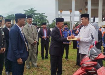 Wakil Bupati Merangin A. Khafidh menyerahkan secara simbolis sepeda motor dinas kepada perwakilan Da’i serta piagam penghargaan kepada siswa berprestasi usai upacara Hardiknas di halaman Kantor Bupati Merangin, Sabtu (2/5/2026). (Dok: Rudi)