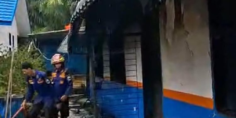 Petugas Damkarmat Muaro Jambi berjibaku memadamkan api yang membakar SMP Negeri 9 Muaro Jambi di Kecamatan Sungai Gelam. (Dok: redaksi)