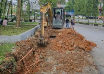 Dinas PUPR Merangin melakukan pembersihan dan pembenahan saluran drainase menggunakan alat berat di salah satu titik rawan genangan di Kota Bangko. (Dok: Deni Satria Budi)