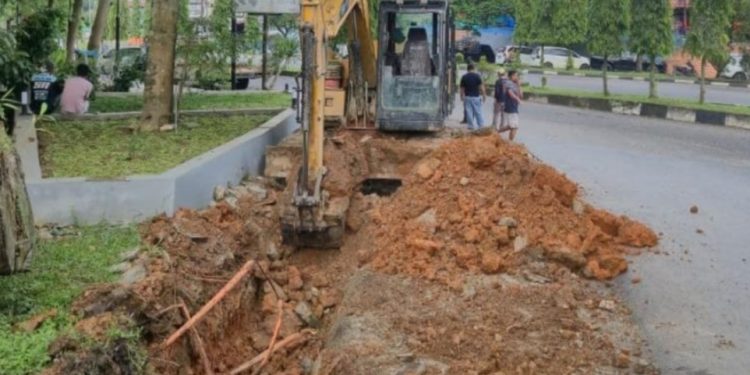 Dinas PUPR Merangin melakukan pembersihan dan pembenahan saluran drainase menggunakan alat berat di salah satu titik rawan genangan di Kota Bangko. (Dok: Deni Satria Budi)