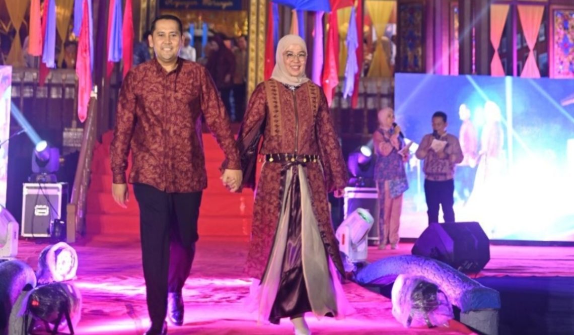 Bupati Merangin M. Syukur bersama Ketua TP-PKK Kabupaten Merangin tampil memukau memperagakan busana batik khas Merangin pada pembukaan Pekan Budaya Merangin 2026 di Anjungan Merangin, Taman Mini Melayu Jambi. (Dok: Diskominfo Merangin)