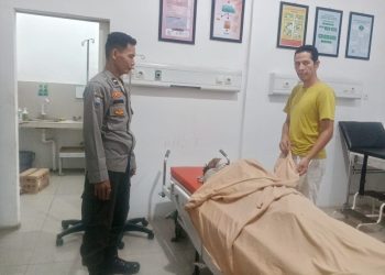 Petugas kepolisian saat melihat korban meninggal dunia di Puskesmas akibat dugaan tawuran antar gangster di kawasan Ness, Kecamatan Pemayung, Kabupaten Batanghari. (Dok: Rahmat)