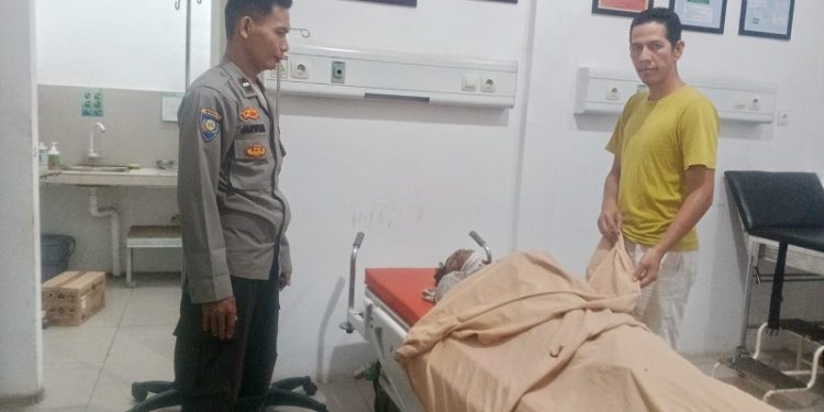 Petugas kepolisian saat melihat korban meninggal dunia di Puskesmas akibat dugaan tawuran antar gangster di kawasan Ness, Kecamatan Pemayung, Kabupaten Batanghari. (Dok: Rahmat)