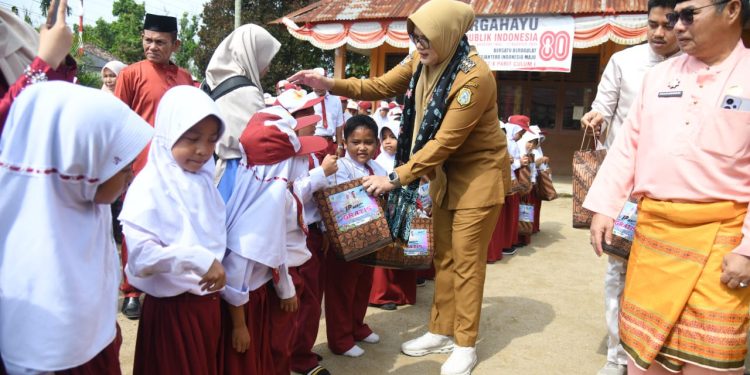 Bupati Tanjabtim Dillah Hikmah Sari saat menyerahkan simbolis seragam sekolah gratis beberapa waktu lalu. (Dok: Rahmat)