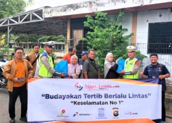 Jurnalis menyerahkan paket sembako kepada anggota Polantas yang sedang bertugas di sejumlah titik pengaturan lalu lintas di Kota Jambi dalam kegiatan "Jurnalis Sapa Polantas", Senin (15/6/2026). (Dok: Rudi)