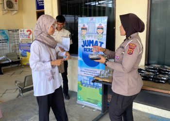Personel Sie STNK Subdit Regident Ditlantas Polda Jambi dipimpin AKP Hadi Siswanto membagikan makanan gratis kepada wajib pajak di Samsat Kota Jambi dalam kegiatan Jumat Berkah, Jumat Berbagi, Jumat (26/6/2026). (Dok: Rudi)