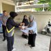 Personel Sie STNK Subdit Regident Ditlantas Polda Jambi membagikan makanan gratis kepada wajib pajak di Samsat Kota Jambi dalam kegiatan Jumat Berkah, Jumat Berbagi, Jumat (12/6/2026). (DOk: Alpin)