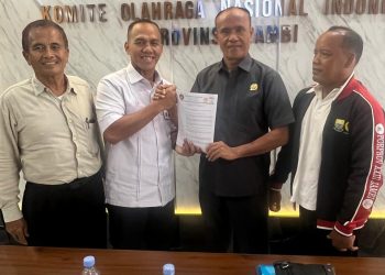 Perwakilan Pengurus Besar Taekwondo Indonesia (PBTI), Hendri Juanda, S.H., menyerahkan tembusan Surat Keputusan Kareteker Pengprov TI Jambi kepada Ketua KONI Provinsi Jambi, Sanusi, di Kantor KONI Jambi. (DOk: Alpin)