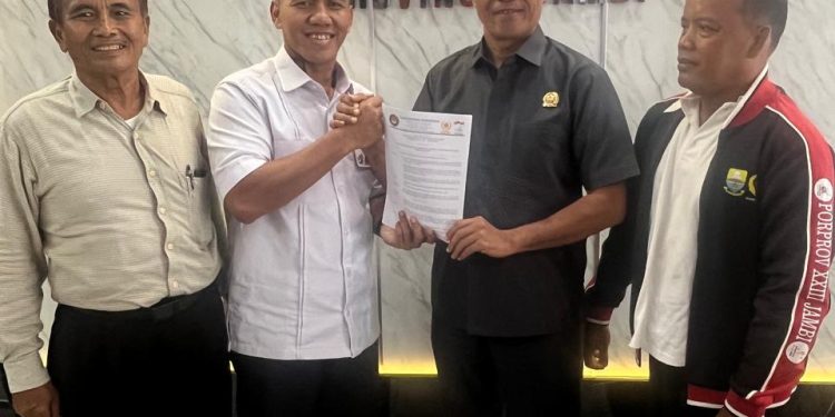 Perwakilan Pengurus Besar Taekwondo Indonesia (PBTI), Hendri Juanda, S.H., menyerahkan tembusan Surat Keputusan Kareteker Pengprov TI Jambi kepada Ketua KONI Provinsi Jambi, Sanusi, di Kantor KONI Jambi. (DOk: Alpin)