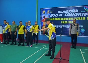 Wakapolda Jambi Brigjen Pol. Benny Ali melakukan pemukulan bola pertama sebagai tanda dibukanya Kejuaraan Bulu Tangkis HUT Bhayangkara ke-80 Tahun 2026 di Hall Badminton Perjuangan Srikayangan. (Dok: Rudi)