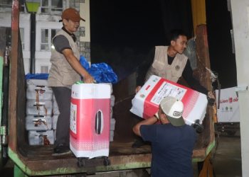 Petugas Panitia Penyelenggara Ibadah Haji (PPIH) Provinsi Jambi menurunkan koper dan barang bawaan jemaah haji di Asrama Haji Antara Jambi. (DOk: Rudi)