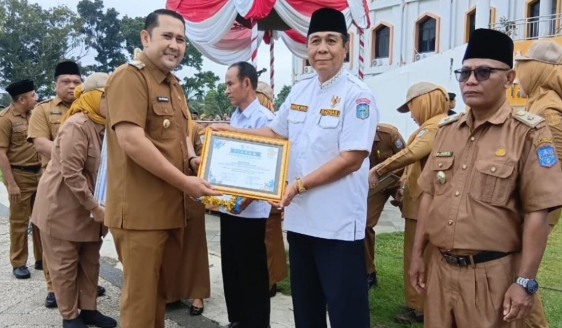 Bupati Merangin H M Syukur memberikan penghargaan usai memimpin upacara peringatan Hari Keluarga Nasional (Harganas) ke-33 di halaman Kantor Bupati Merangin. (Dok: Rahmat)