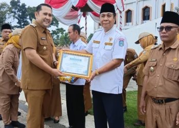 Bupati Merangin H M Syukur memberikan penghargaan usai memimpin upacara peringatan Hari Keluarga Nasional (Harganas) ke-33 di halaman Kantor Bupati Merangin. (Dok: Rahmat)