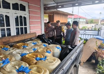 Petugas Satreskrim Polres Kerinci menunjukkan barang bukti berupa 59 jerigen berisi solar subsidi yang diamankan dalam pengungkapan dugaan penyalahgunaan BBM di Desa Air Teluh, Kecamatan Kumun Debai. (Dok: Rudi)