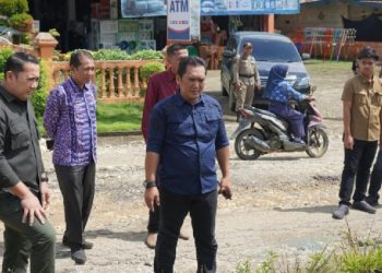 Bupati Merangin H. M. Syukur didampingi tim Dinas PUPR meninjau kondisi jalan rusak di depan Kantor Camat Pamenang Selatan.