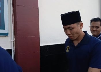 Alung saat menuju ruang sidang di Pengadilan Negeri Jambi. (Dok: Rudi)