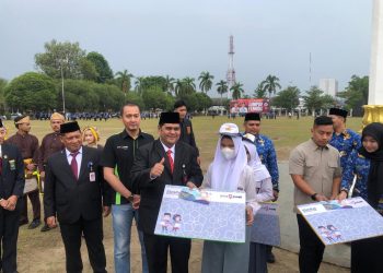 Direktur Operasional Bank Jambi didampingi Pimpinan Cabang KCU saat menyerahkan bantuan kepada siswa