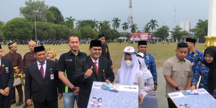 Direktur Operasional Bank Jambi didampingi Pimpinan Cabang KCU saat menyerahkan bantuan kepada siswa