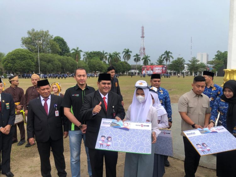 Direktur Operasional Bank Jambi didampingi Pimpinan Cabang KCU saat menyerahkan bantuan kepada siswa
